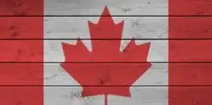 Canada flag depicted in bright paint colors on old wooden wall close up